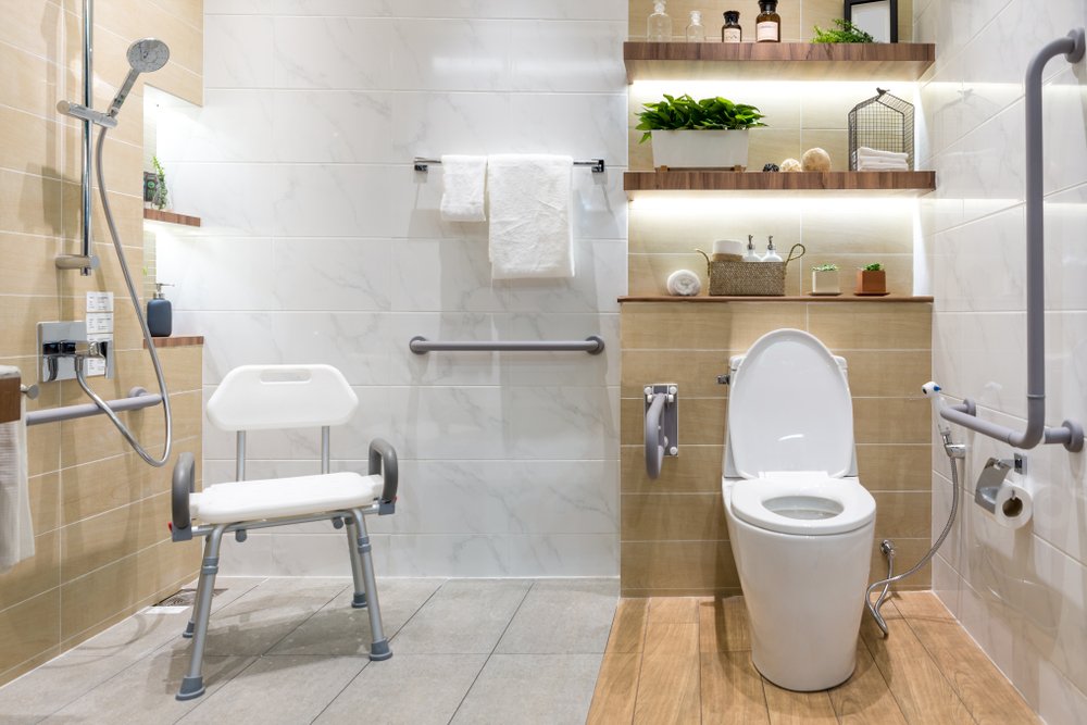 image An ADA-compliant bathroom featuring a shower with a built-in seat, grab bars for safety, and an accessible toilet with support rails, designed for individuals with mobility challenges.